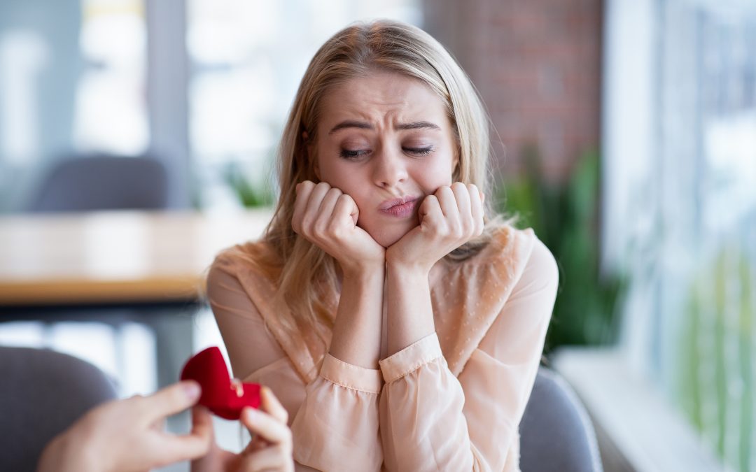 Bored millennial lady not willing to accept engagement ring, rejecting marriage proposal at cafe. Young woman saying NO to her boyfriend, refusing to marry with wrong candidate
